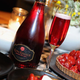 Red dessert wine next to plated strawberry tart